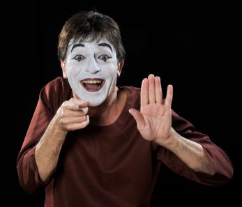 Pantomime-Jomi-mit-weissem-Gesicht-zeigt-mit-Finger-flache-Hand